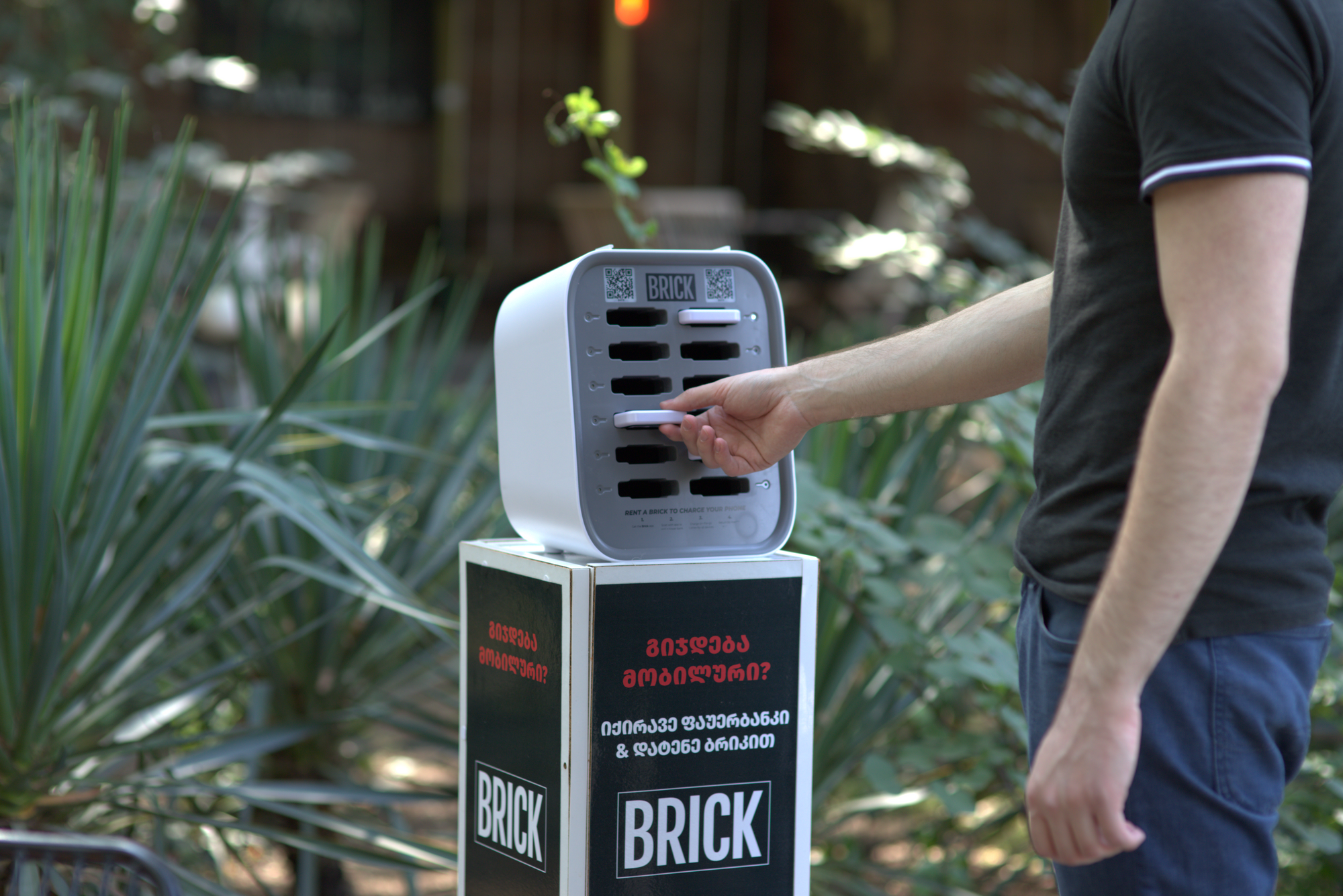 A person returning back a powerbank to the charging station. 