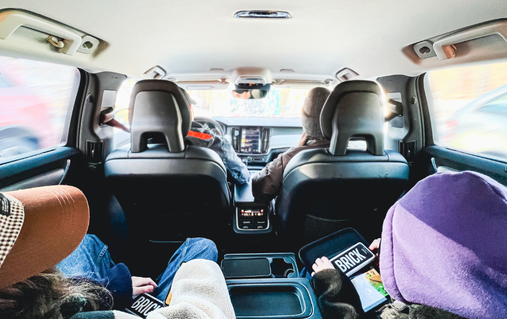 Picture of people sitting in a car, while holding Brick powerbanks. 