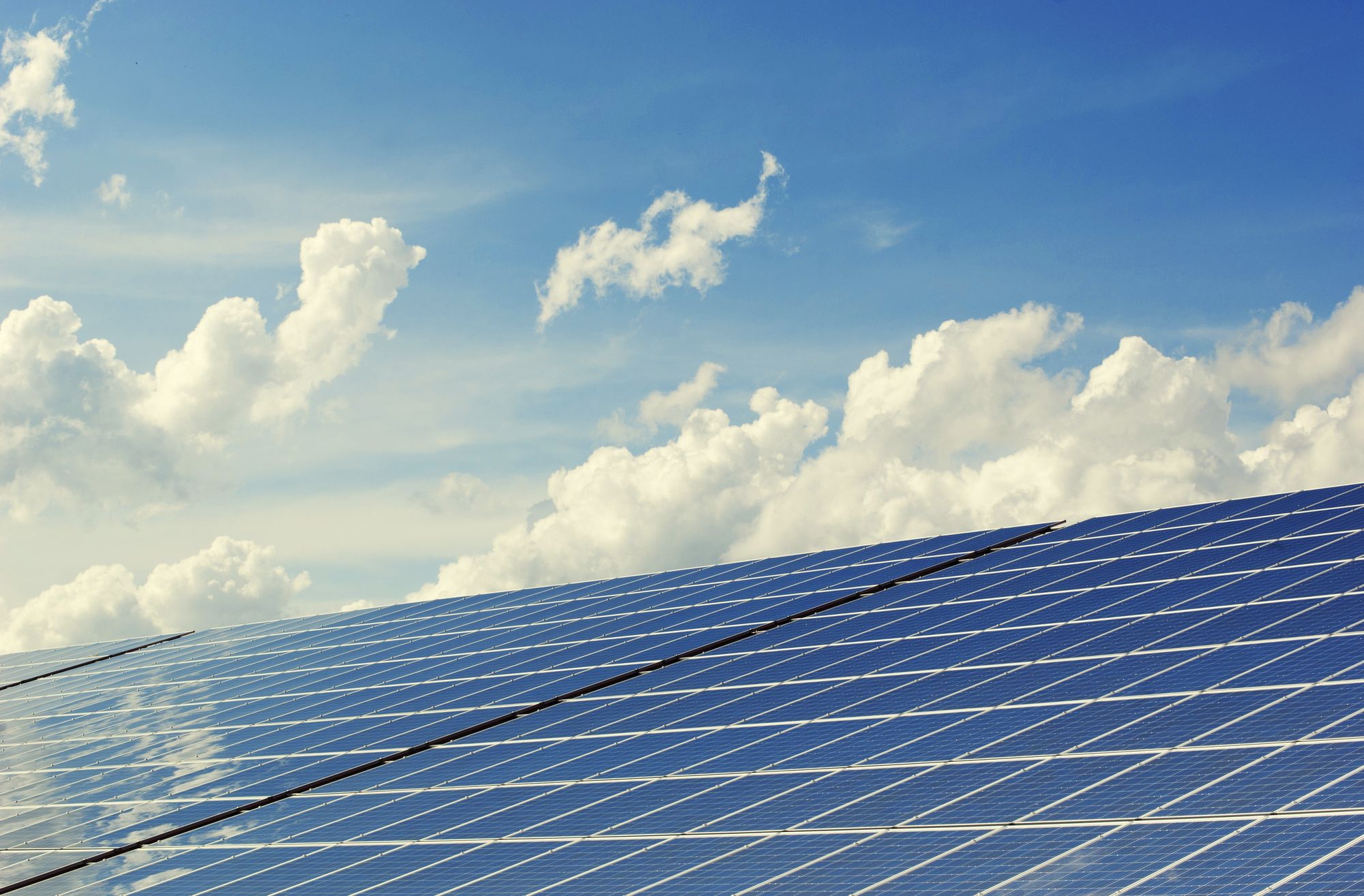 Solar panels with a blue sky with clouds in the background