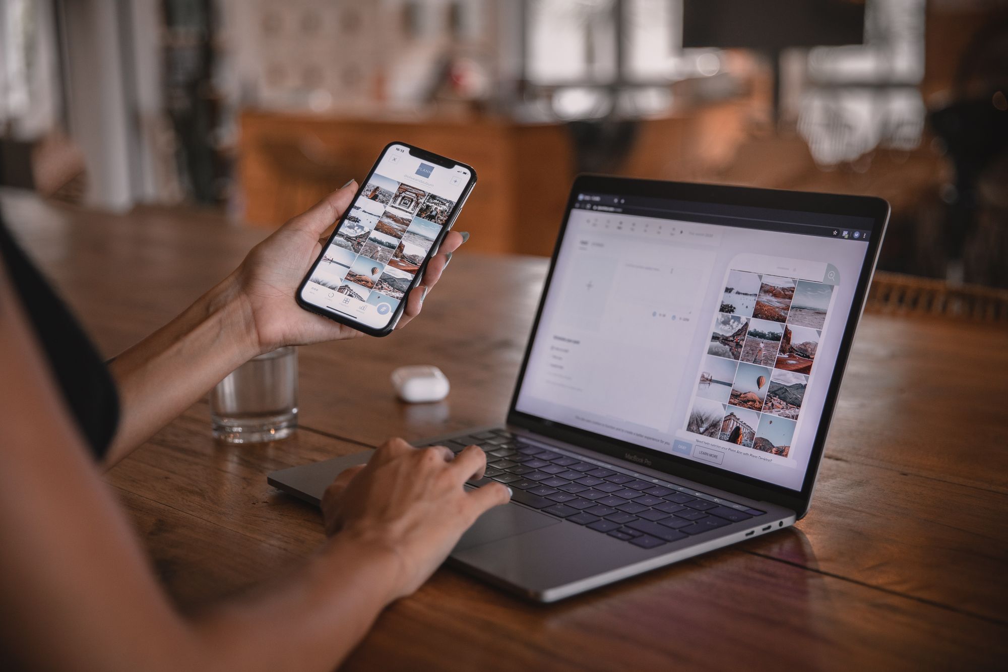 A person sitting with their laptop and a phone in the other hand, examples of end user devices. 