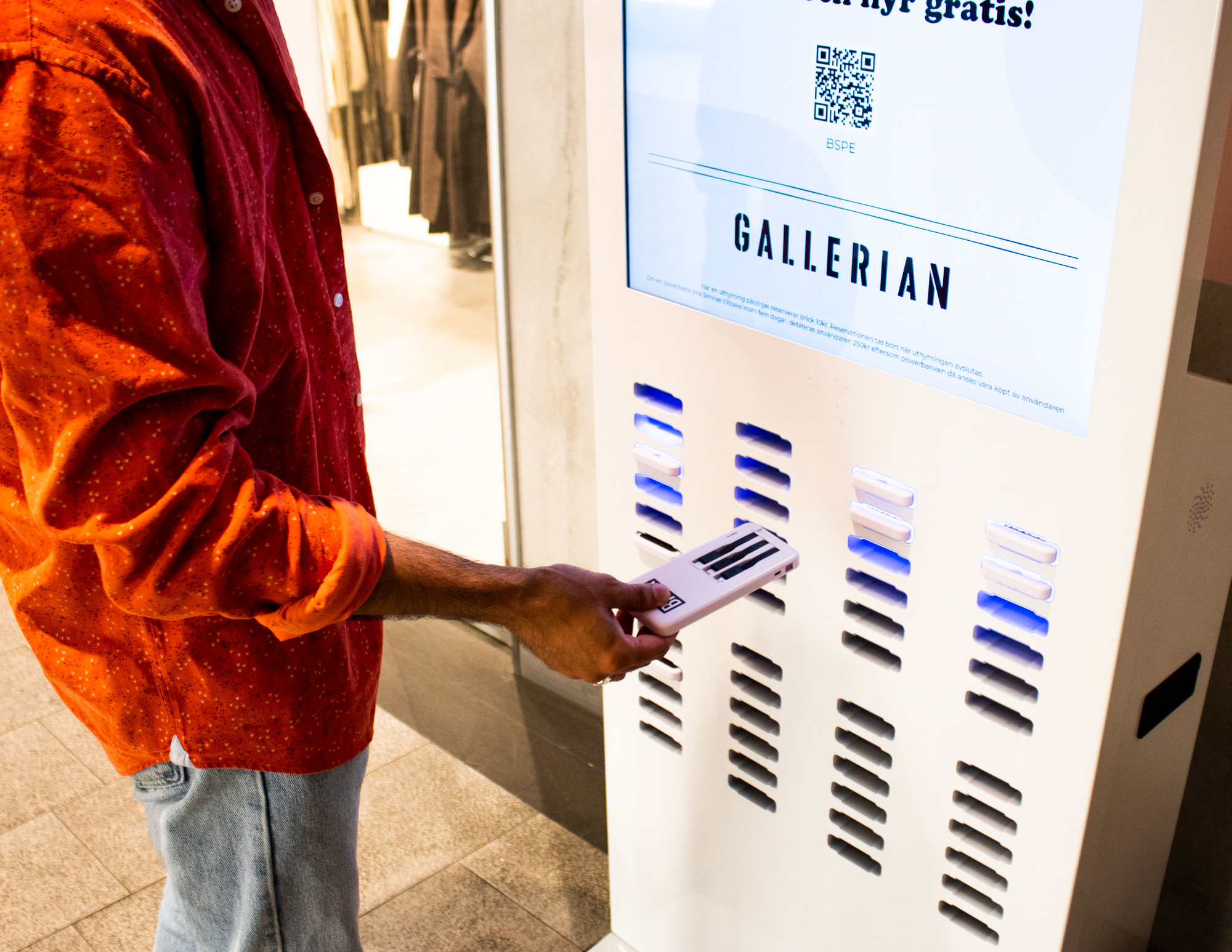 Picture of someone returning a Brick powerbank to a 48-slot station.